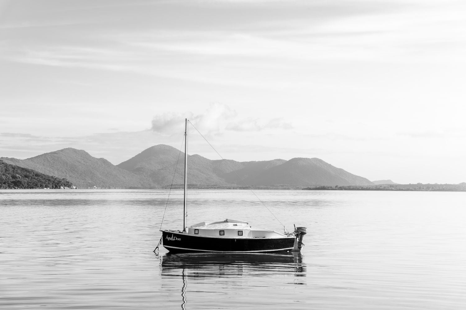 Un barco no por do sol em preto e blanco
